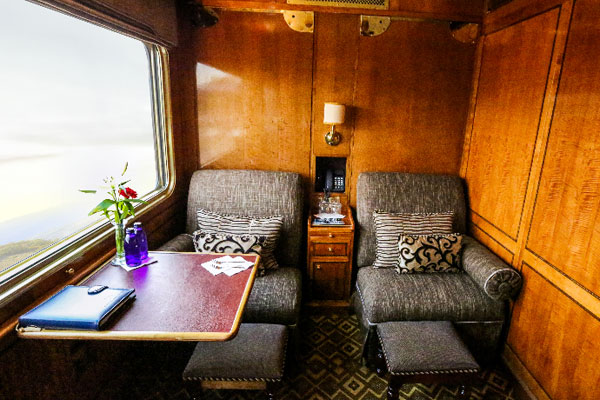 Palace on Wheels heritage train with royal blue livery and traditional Indian architecture backdrop