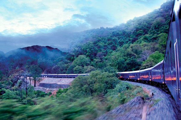 Maharajas Express luxury train at historic Indian railway station with elegant burgundy carriages