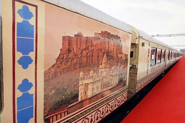 Palace on Wheels heritage train with royal blue livery and traditional Indian architecture backdrop